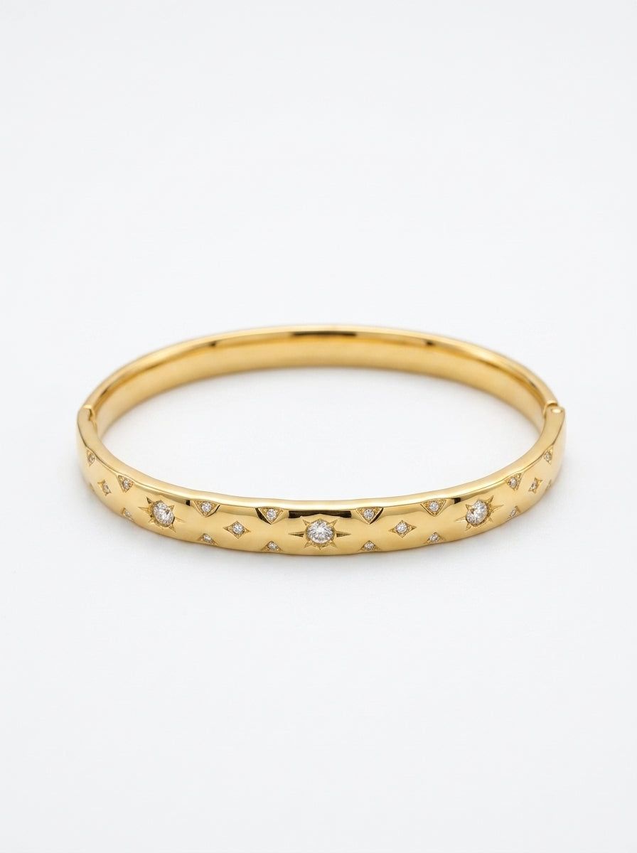 Gold bracelet with embedded diamonds on a white background