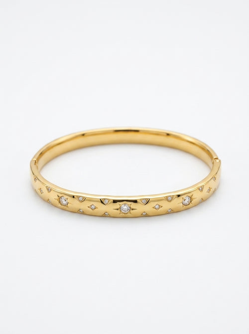 Gold bracelet with embedded diamonds on a white background