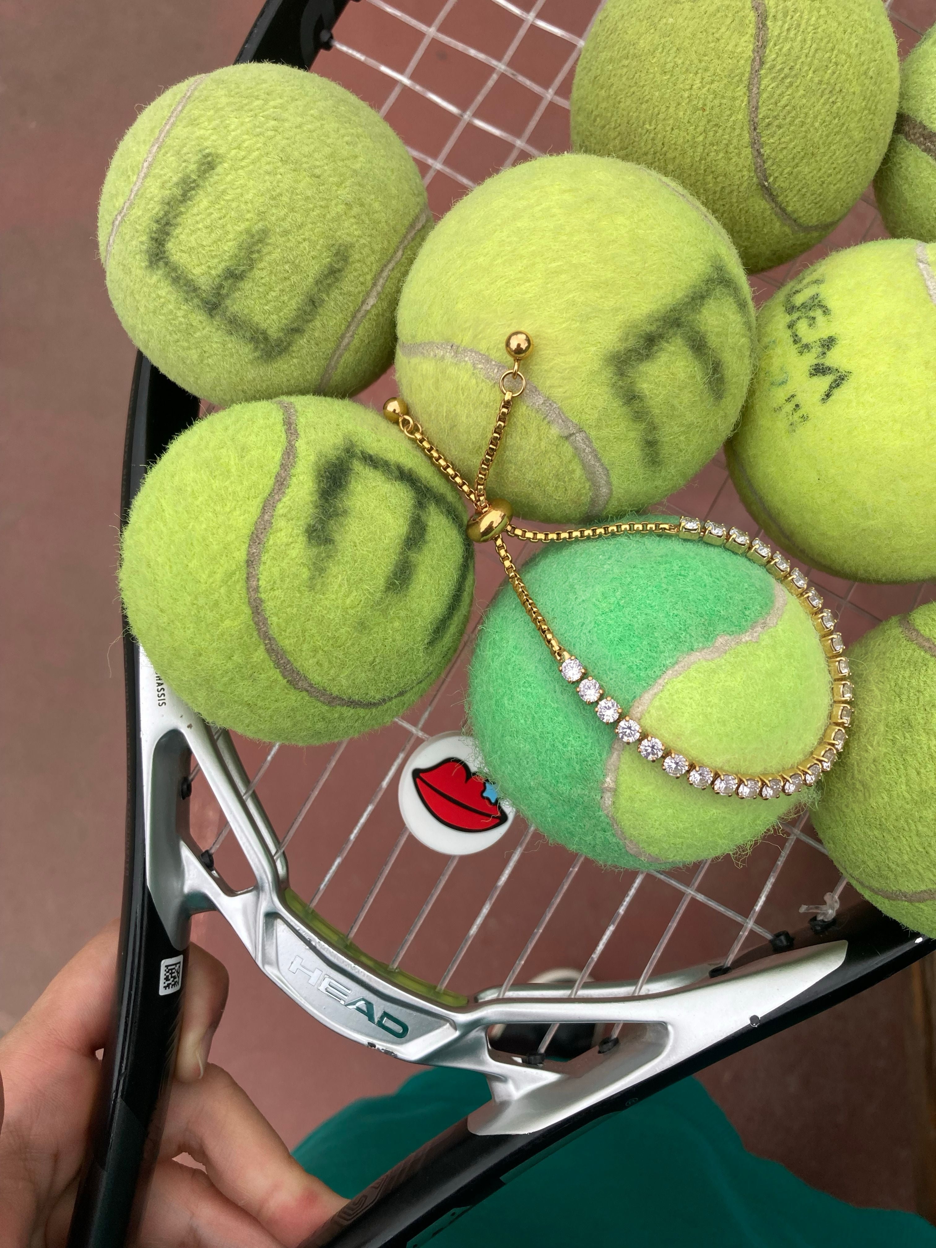 Tennis racket with tennis balls and a diamond-studded tennis ball on a tennis court background